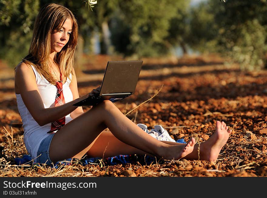 Girl with a laptop in a field in autumn