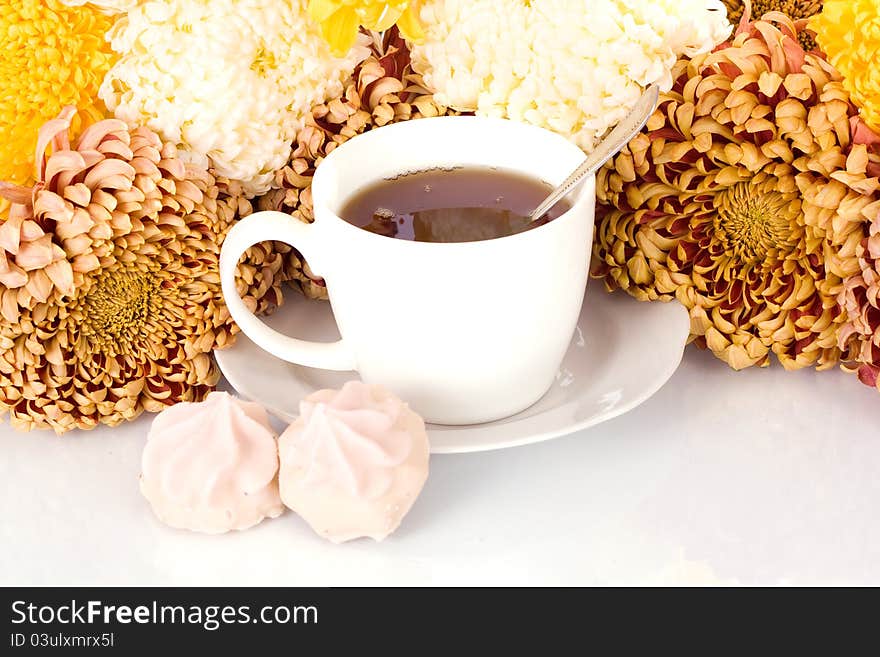 Glass of tea and chrysanthemums  on white background