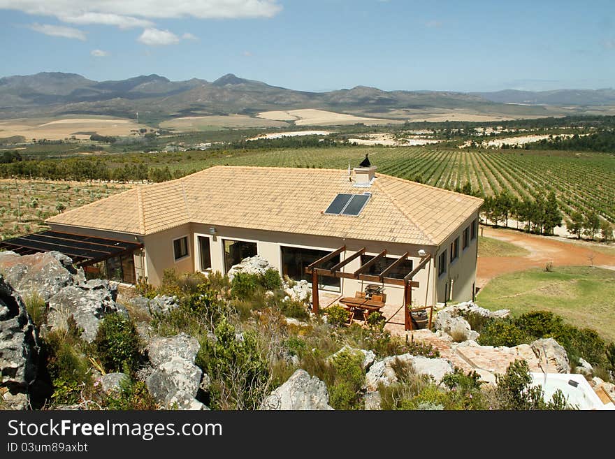 Summer Spanish style villa home with mountains and olive groves in the landscape in the Overberg wine route region, Western cape, South Africa. Summer Spanish style villa home with mountains and olive groves in the landscape in the Overberg wine route region, Western cape, South Africa