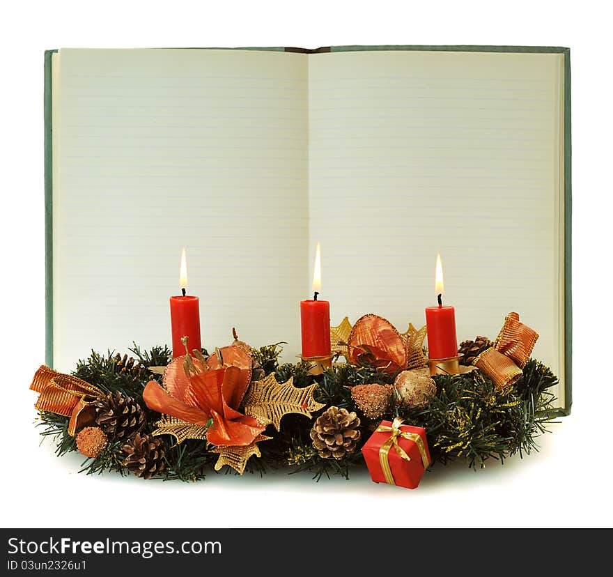 Blank pages of old open notebook bordering with christmas decoration and red burn candle. Blank pages of old open notebook bordering with christmas decoration and red burn candle