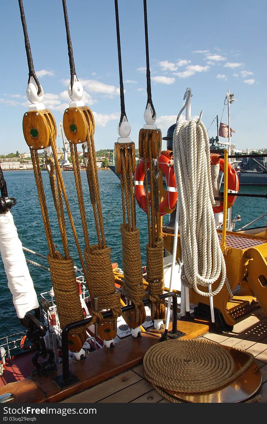 Ship equipment at ancient nautical vessel. Marine ropes with wooden rigging on the seascape view. Wooden block, pulley and hemp ropes -  tackle on the old ship. Ship equipment at ancient nautical vessel. Marine ropes with wooden rigging on the seascape view. Wooden block, pulley and hemp ropes -  tackle on the old ship.