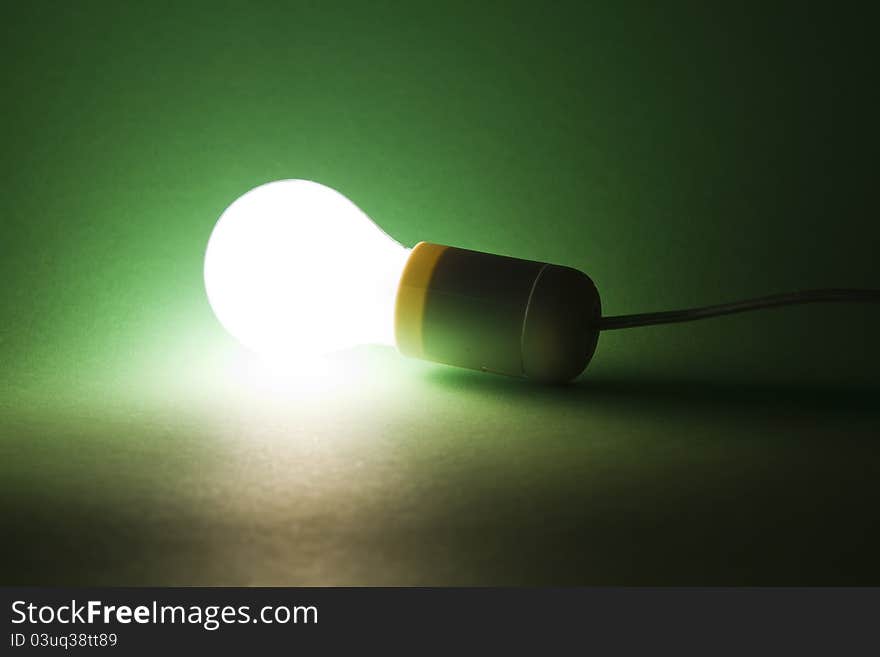 Lightbulb laying on green background. Lightbulb laying on green background