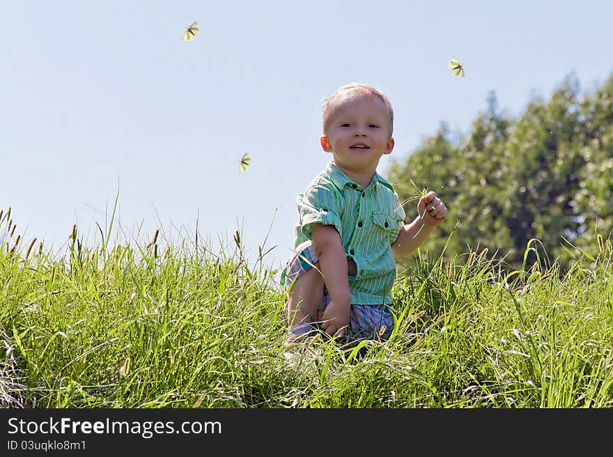 Portrait of a Boy in the sky and grass with butterflies