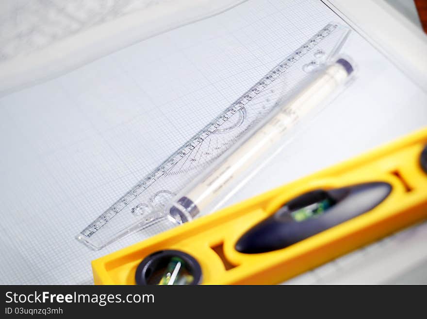 Graph paper, ruler and water level. Workplace Designer. Shot with shallow depth of field. Selective focus. Graph paper, ruler and water level. Workplace Designer. Shot with shallow depth of field. Selective focus.