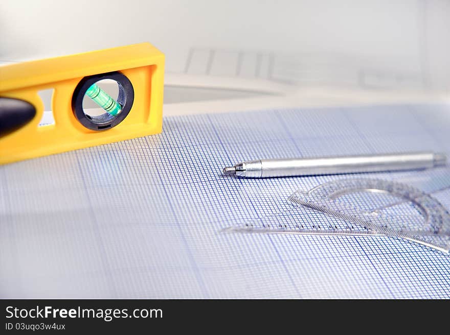 Pencil, graph paper, water level and ruler. Workplace Designer. Shot with shallow depth of field. Selective focus. Pencil, graph paper, water level and ruler. Workplace Designer. Shot with shallow depth of field. Selective focus.