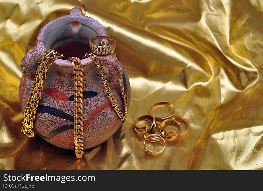 Vase with jewelry over gold background. Vase with jewelry over gold background