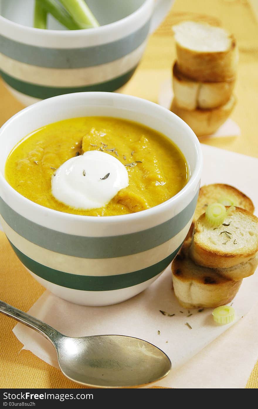 Cup of fresh tasty carrot and thyme soup with fresh bread. Cup of fresh tasty carrot and thyme soup with fresh bread