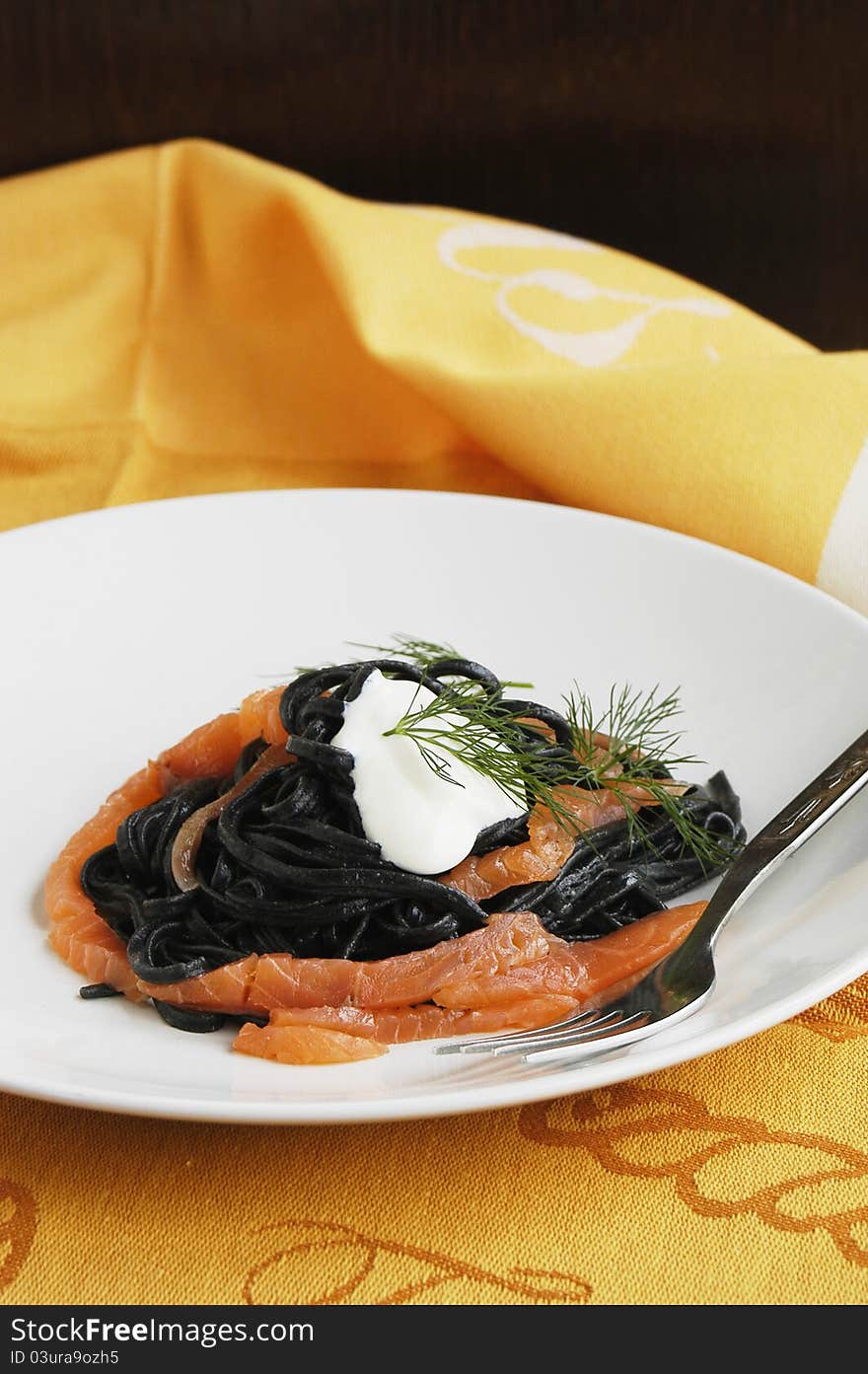 Plate of fresh black linguine and tasty smoked salmon. Plate of fresh black linguine and tasty smoked salmon