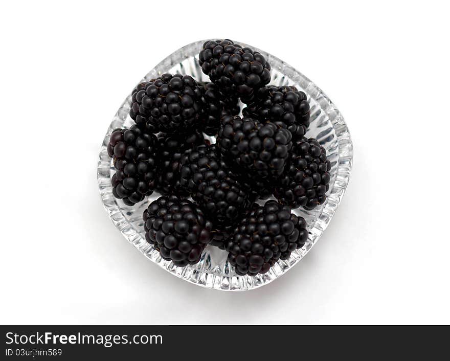 Blackberries on a transparent plate on a white background