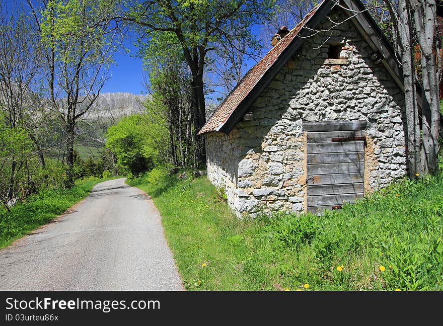 Small restored shepherd farmhouse in natural park by a sunny day near a mountain road