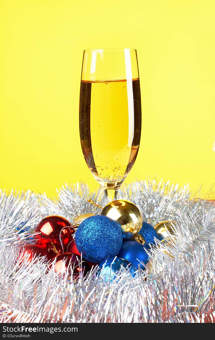 Christmas and New Year decoration- balls, glasse of champagne .On yellow background