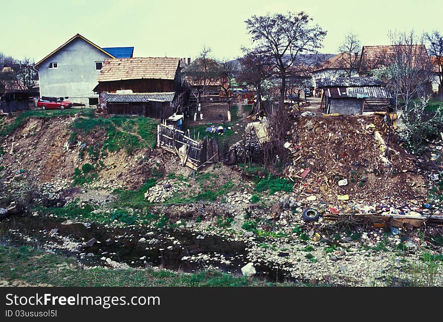 Gypsy village near Cluj. Garbage and cottages on a river bank. Film scan