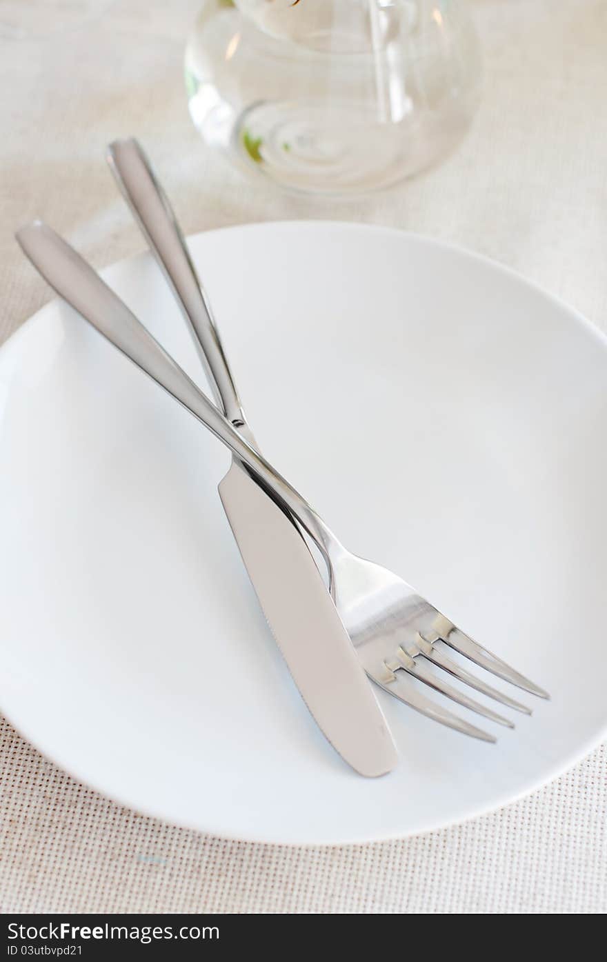 An elegant dining table setting with a white cloth, fork and knife