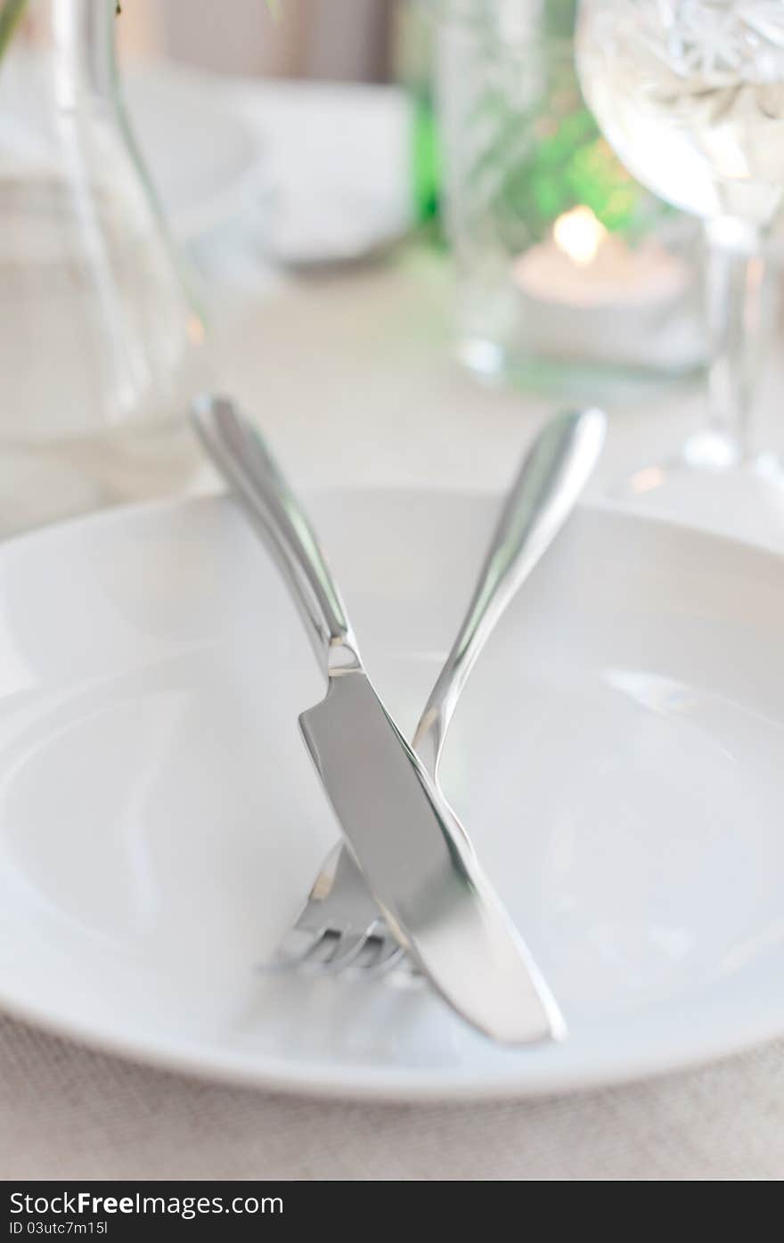 An elegant dining table setting with a white cloth, fork and knife