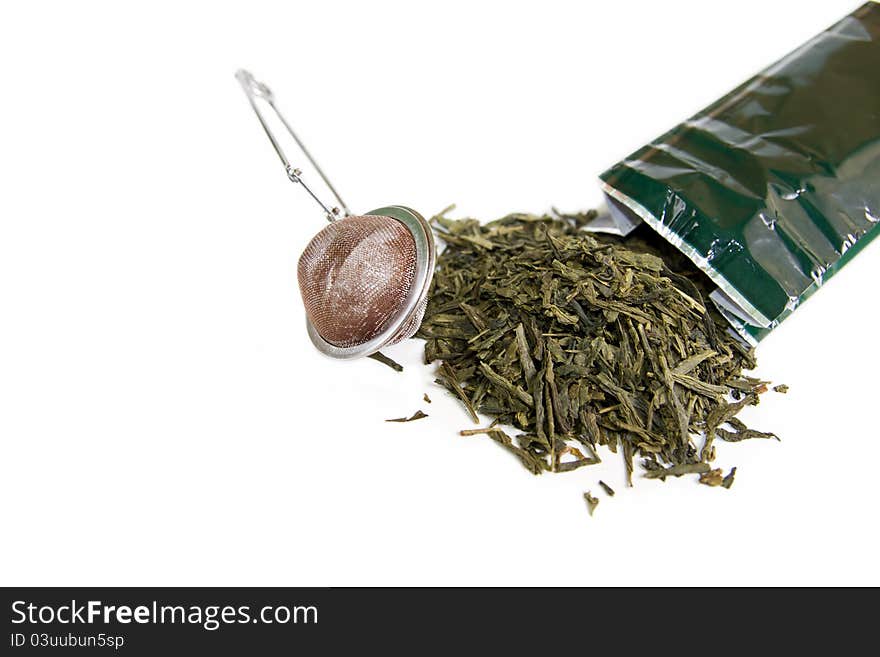 Leaves of green tea with strainer