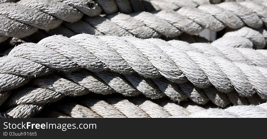 A closeup of white thick rope like the kind use in ship rigging.