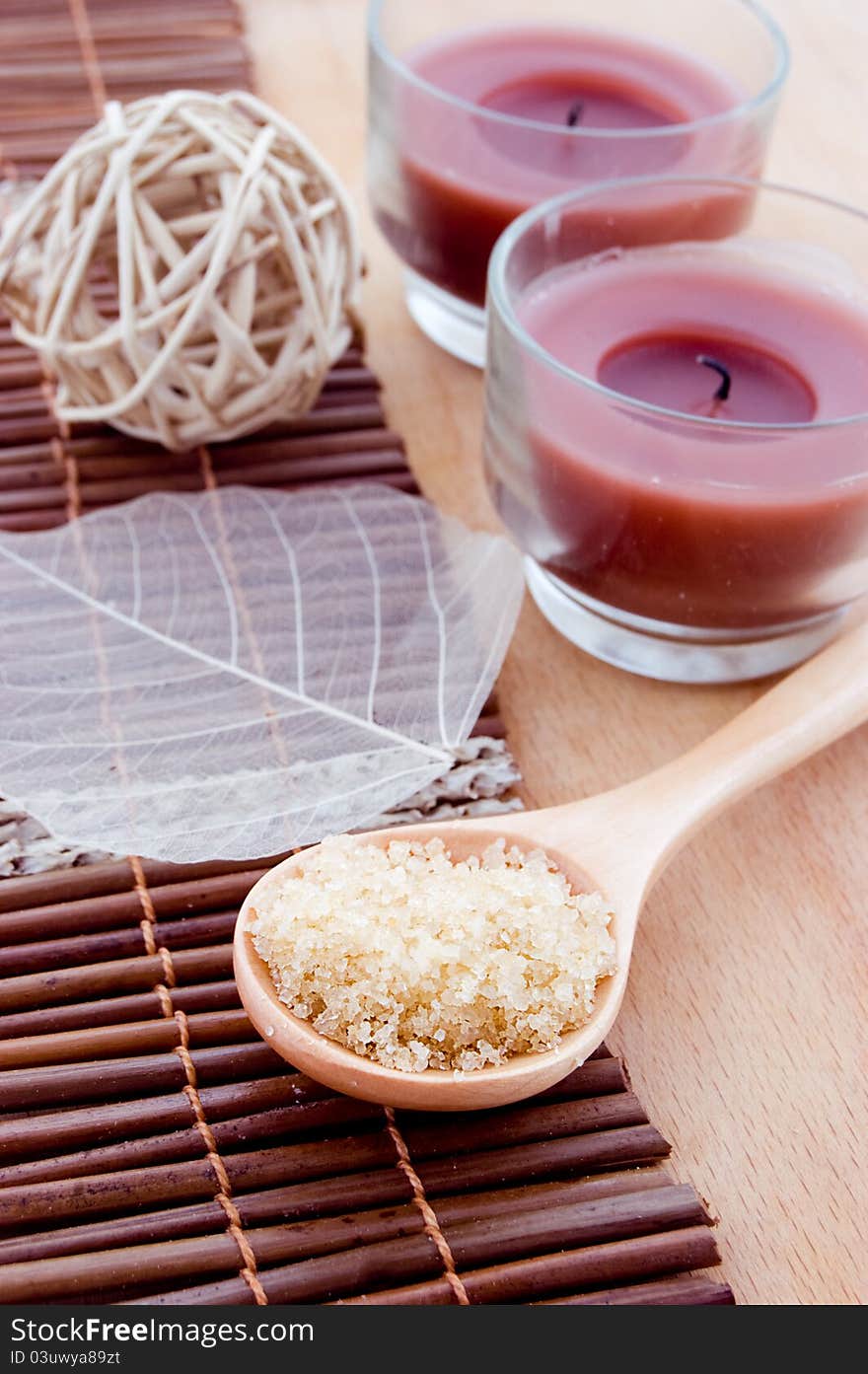 Salt in wooden spoon and other spa products with candles