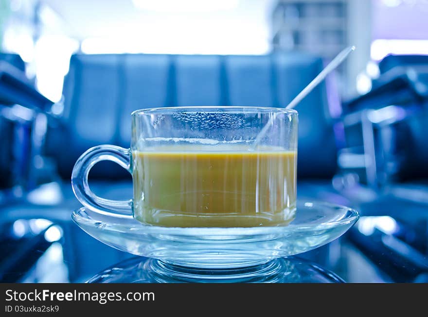 Hot coffee in glass cup with plate on the table with reflection