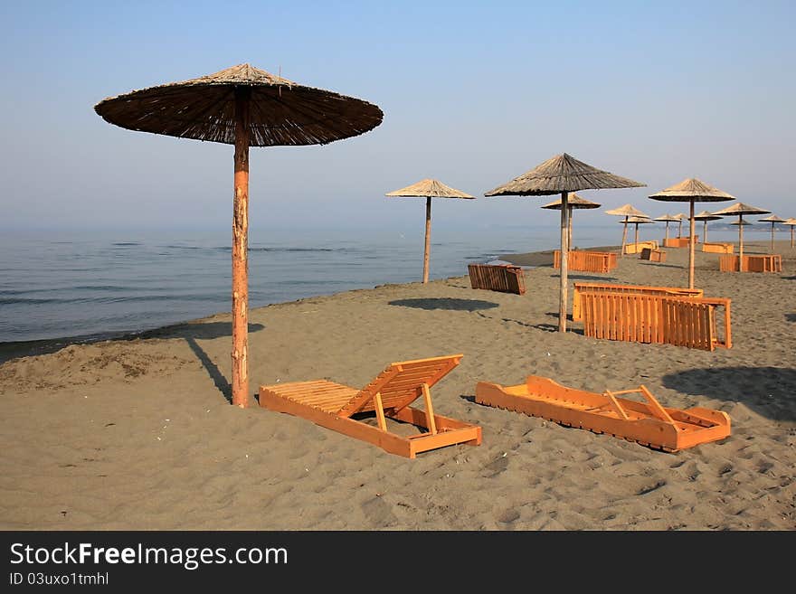 Sun umbrellas and chaise longue on the beach at Adriatic Sea - Montenegro, Ulcinj.