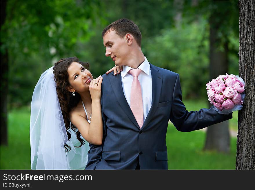 Happy bride embrase groom with bouquet