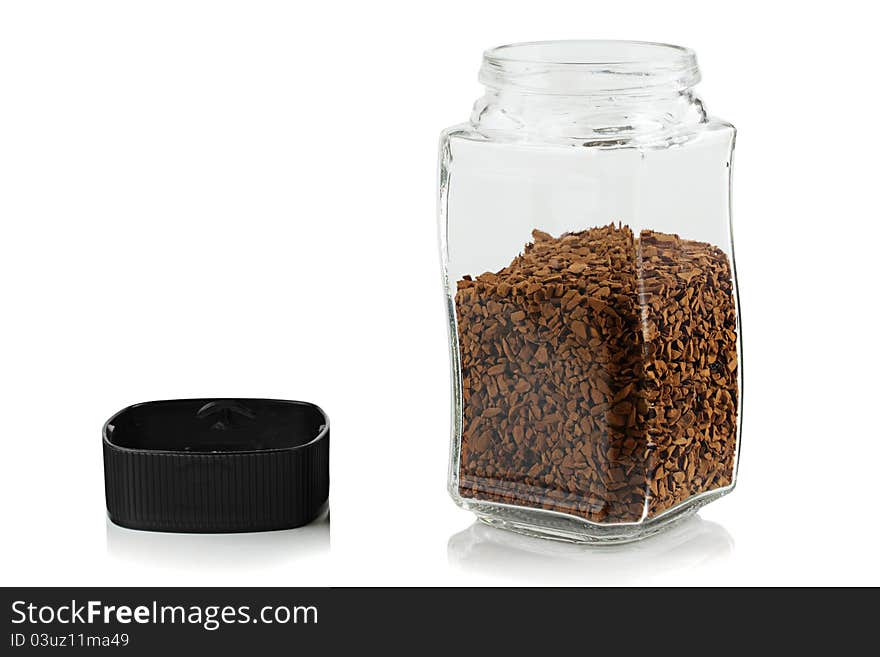 The open glass jar of instant coffee.