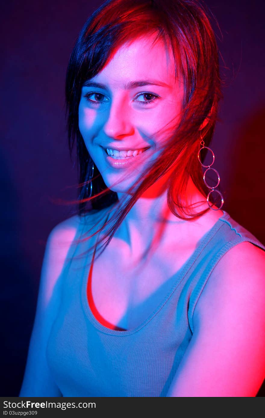 Smiling girl at disco in color lights. Smiling girl at disco in color lights.