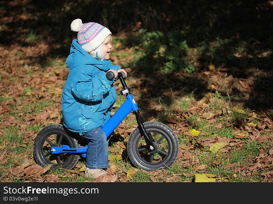 A child riding a bicycle and smiling. A child riding a bicycle and smiling