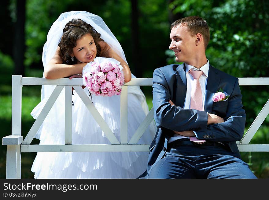 Bride and groom on the bench in summer park. Bride and groom on the bench in summer park