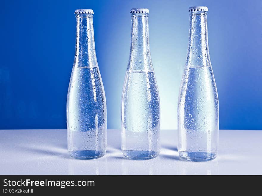 Bottles with water  on the blue background. Bottles with water  on the blue background