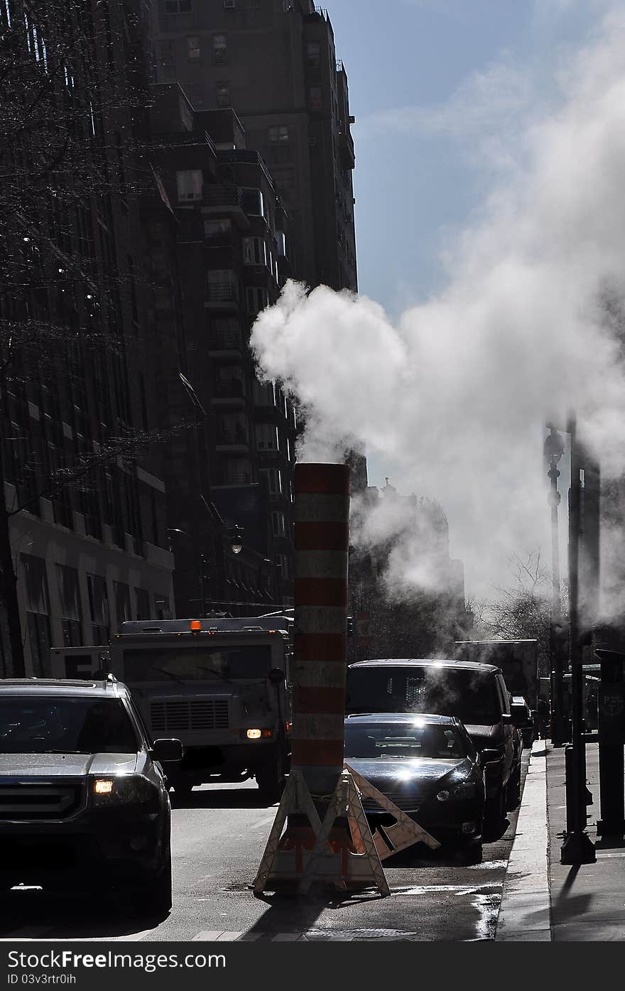 White smoke coming out of a street industrial chimney, photo taken in New York. White smoke coming out of a street industrial chimney, photo taken in New York