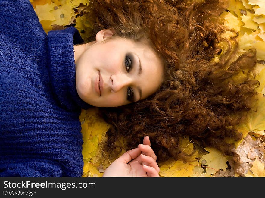 Young woman lying down in the fall leaves. Young woman lying down in the fall leaves