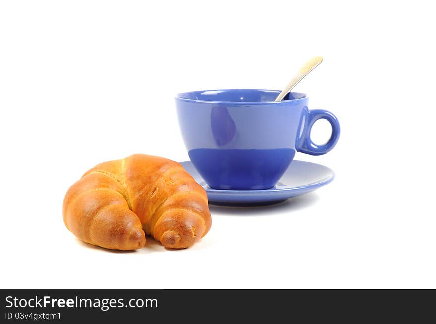 Blue cup with tea and croissant