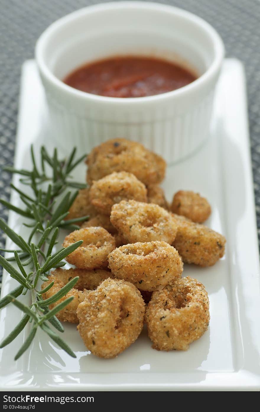 Breaded and deep fried calamari rings with marinara sauce. Breaded and deep fried calamari rings with marinara sauce