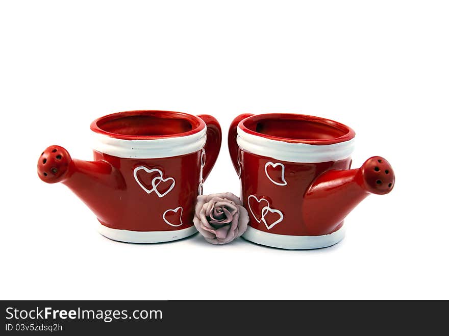 Two red watering cans with hearts