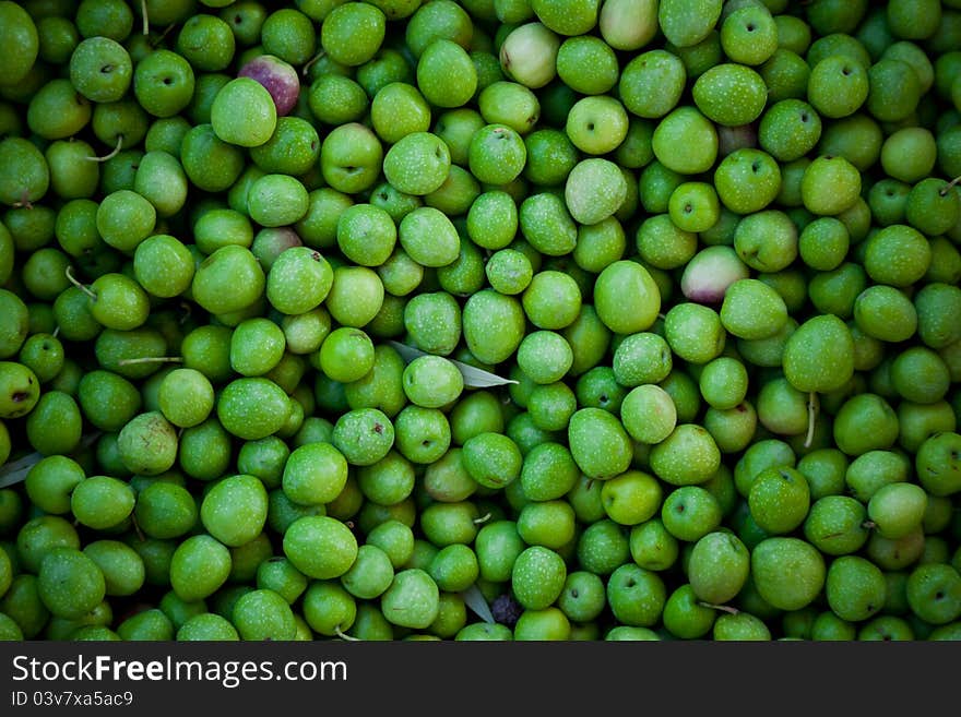 Green olives background in a local market. Natural light.