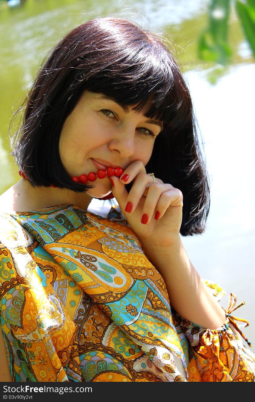 Woman with red necklace near her lips. Woman with red necklace near her lips