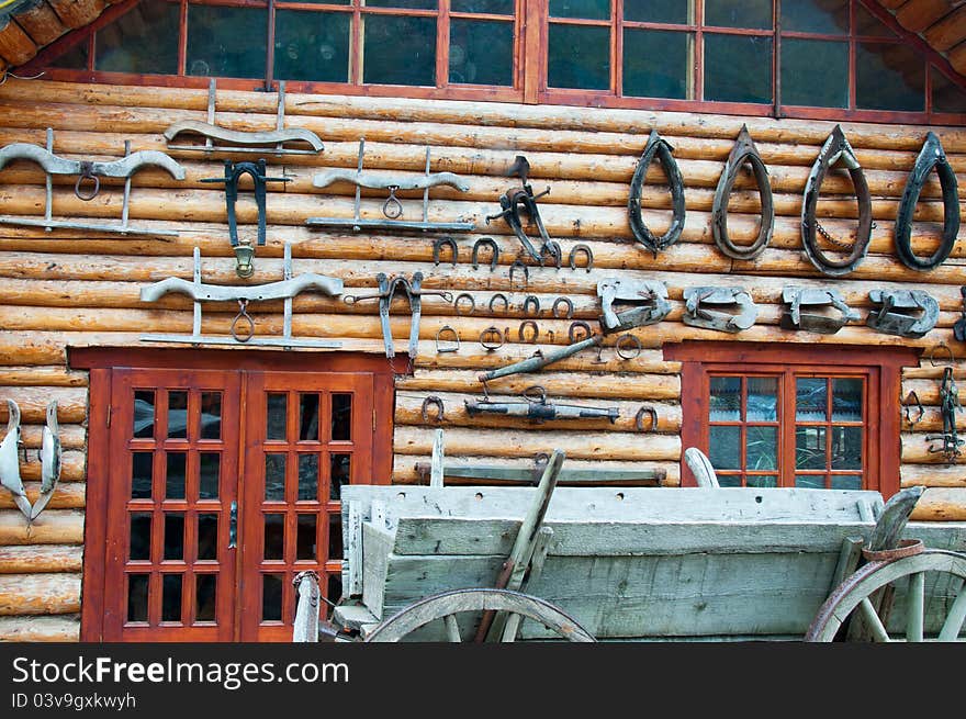 Horseshoes and other supplies for the horses on display on the wall of wooden houses