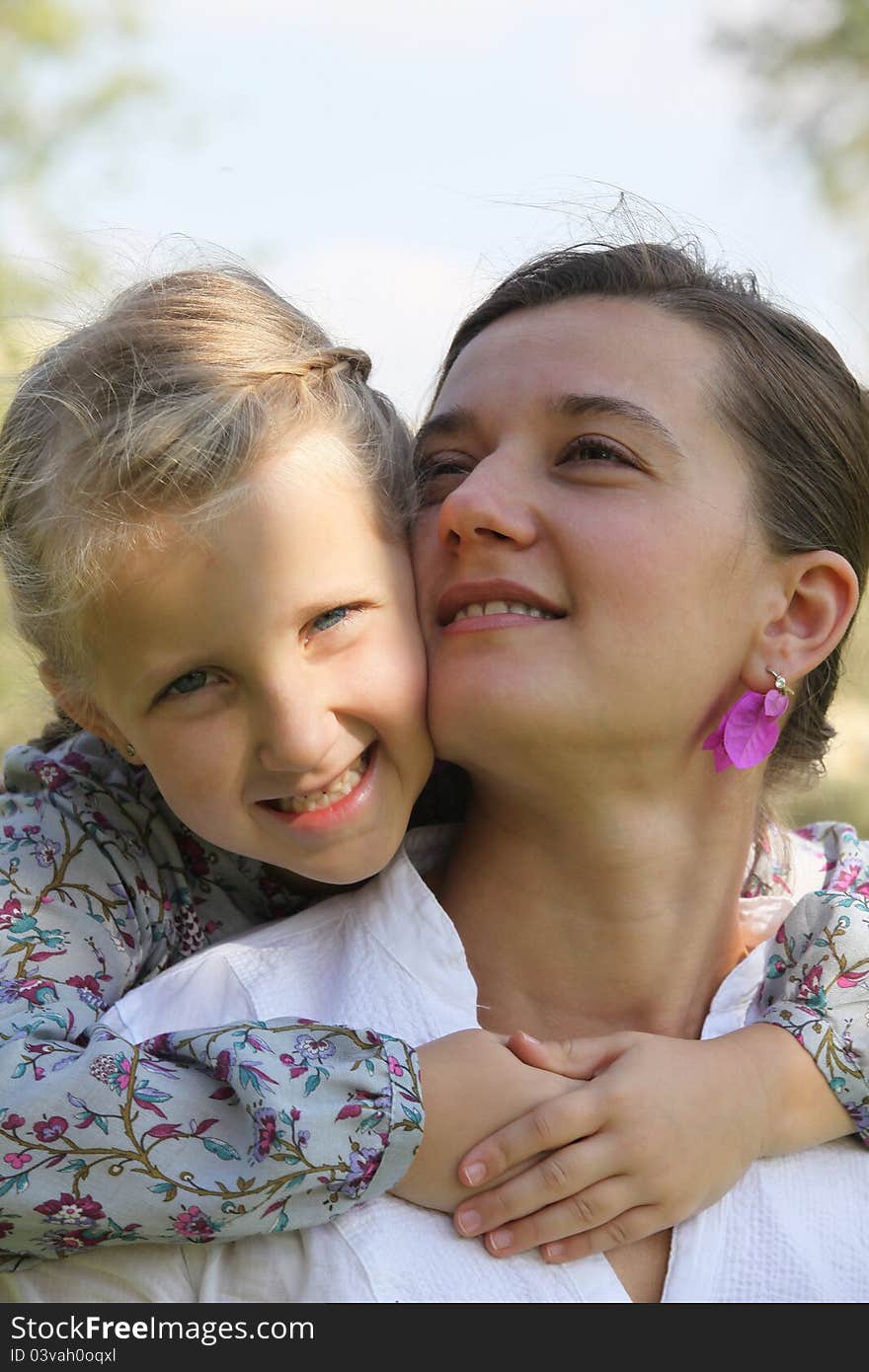 Daughter hugging her mother summer sun day