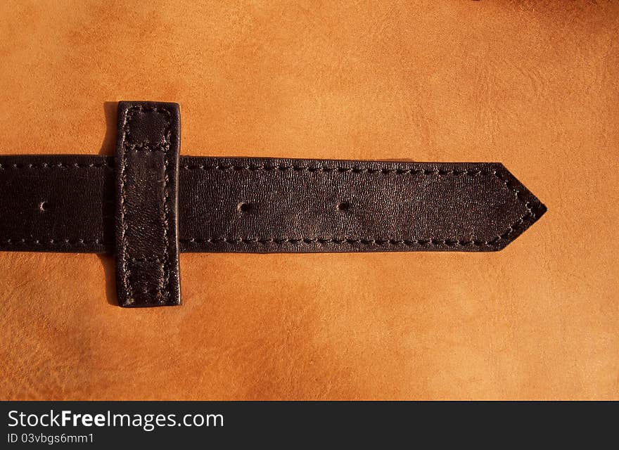 Leather bag detail a belt on beige background. Leather bag detail a belt on beige background