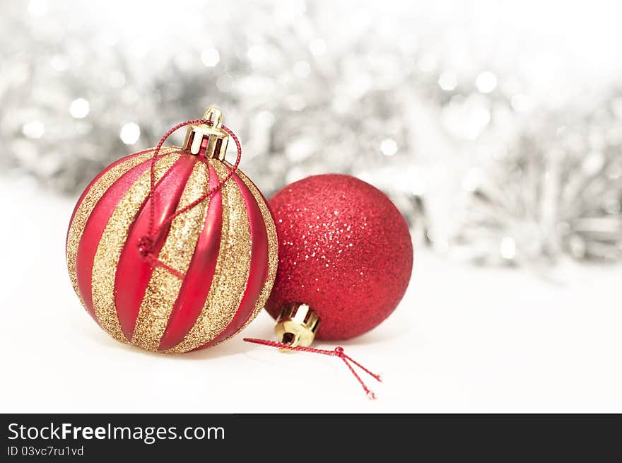 Gold & red christmas baubles with tinsel in the background.