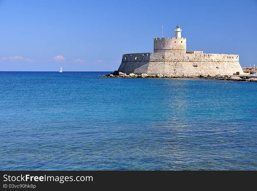 This ancient fort guards the entrance to mandraki harbour in rhodes greece. This ancient fort guards the entrance to mandraki harbour in rhodes greece