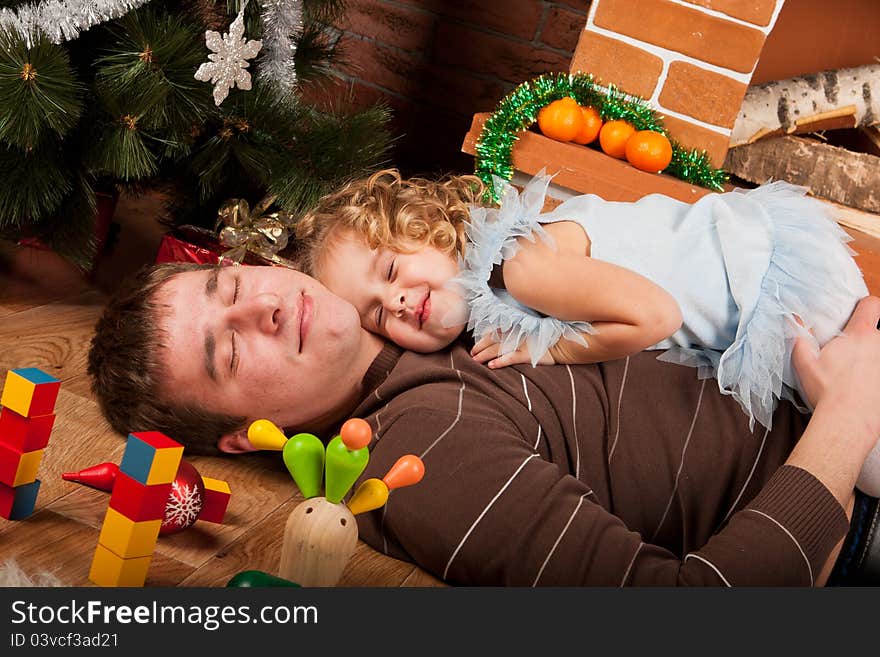 Little girl play with dad  near Christmas tree