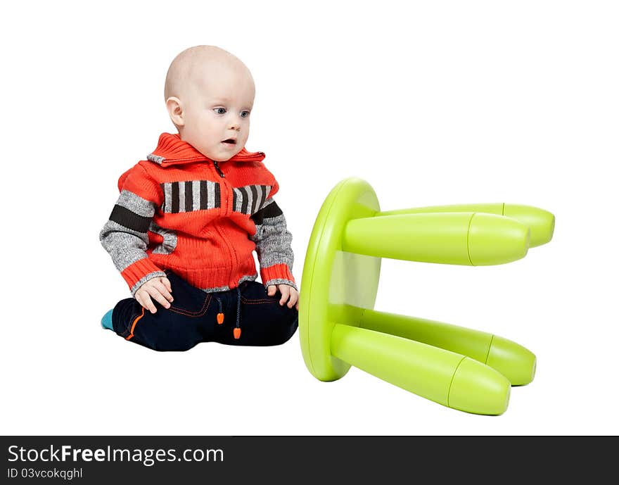 Child dropped a plastic chair in the studio on a white background