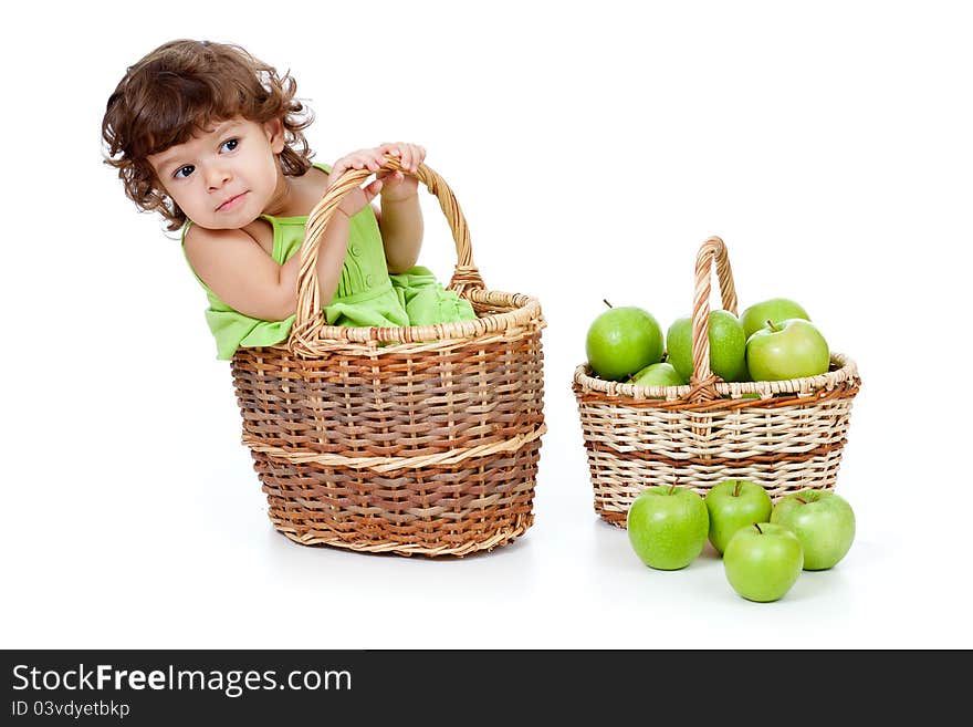 Adorable little girl with green apples in basket