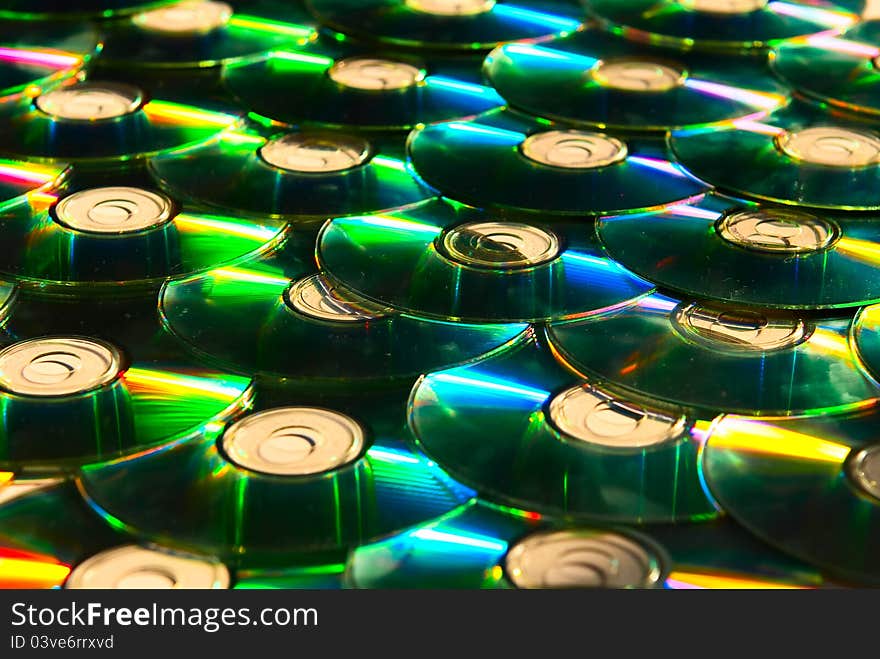 A lot of shiny cd discs lie on each other and shine