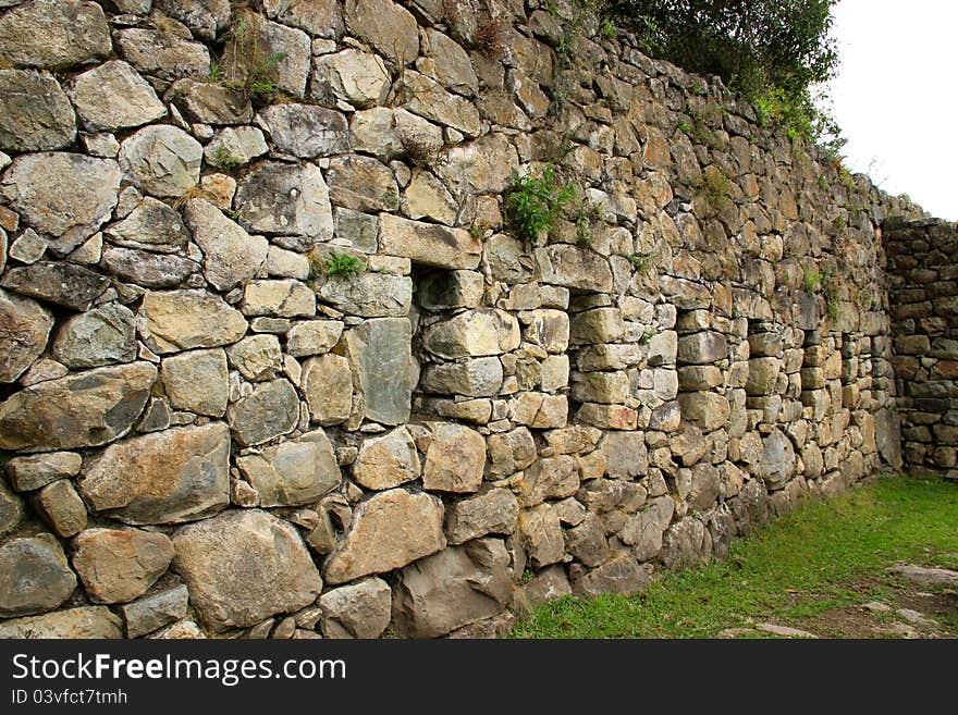 Wall of a fallen house in Machu Picchu ruins.  Inca stone rock wall with spaces (small window like space) for art. Wall of a fallen house in Machu Picchu ruins.  Inca stone rock wall with spaces (small window like space) for art.