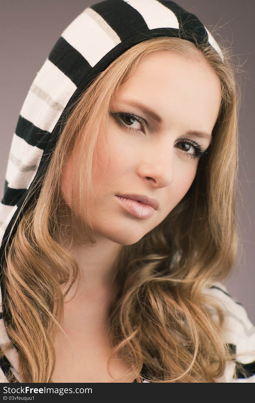 Portrait of pretty young girl in hood with black and white stripes. Portrait of pretty young girl in hood with black and white stripes