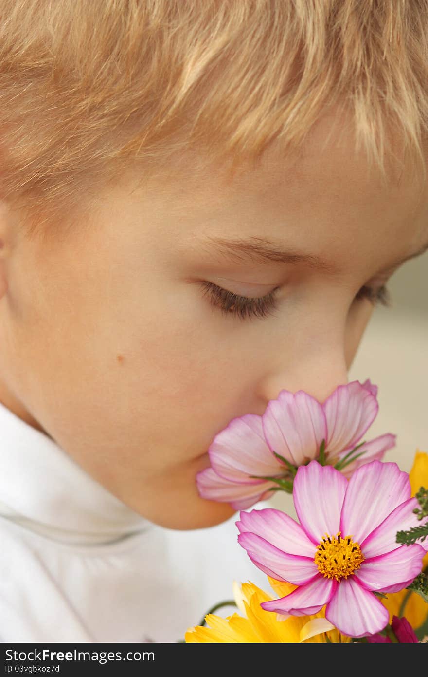 Portrait of the boy with a bouquet of flowers.