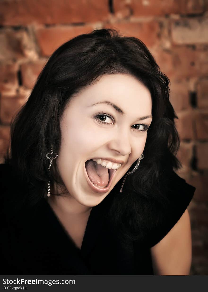 Surprised young girl on brick wall background