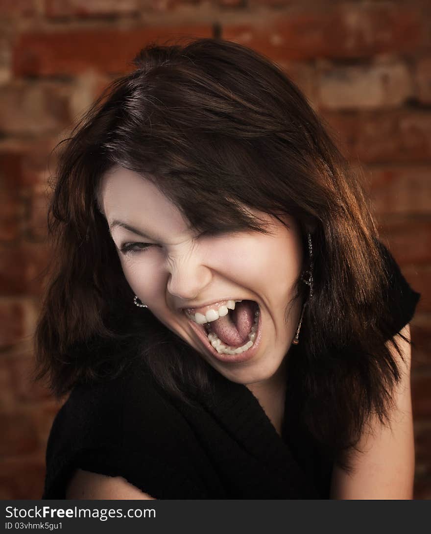 Joyful young girl on brick wall background